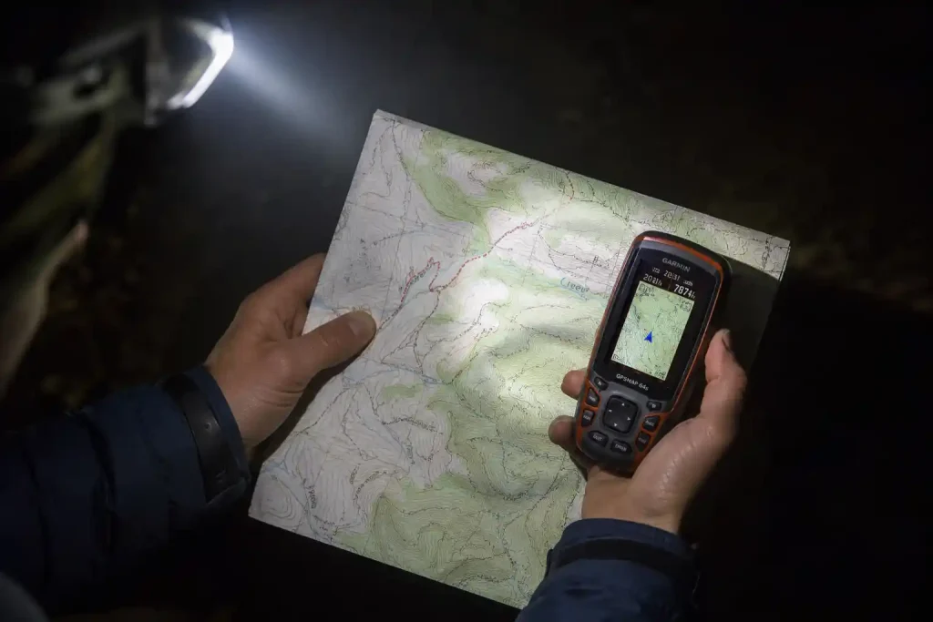 hiker's hands holding a glowing GPS device